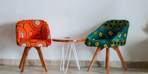 two assorted color padded chairs near side table